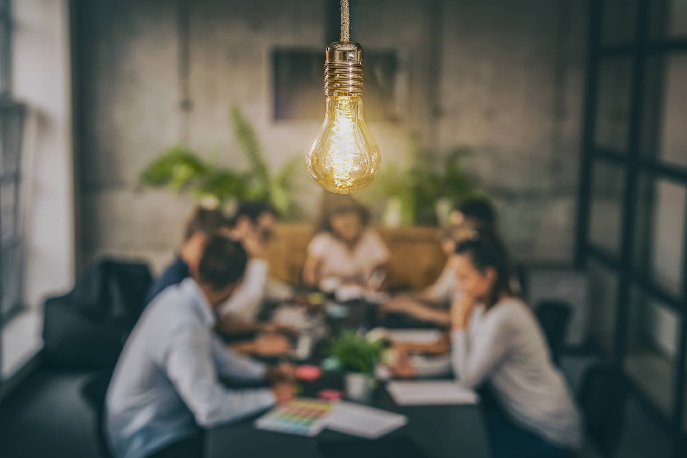 Marketing team sitting around with lightbulb over them