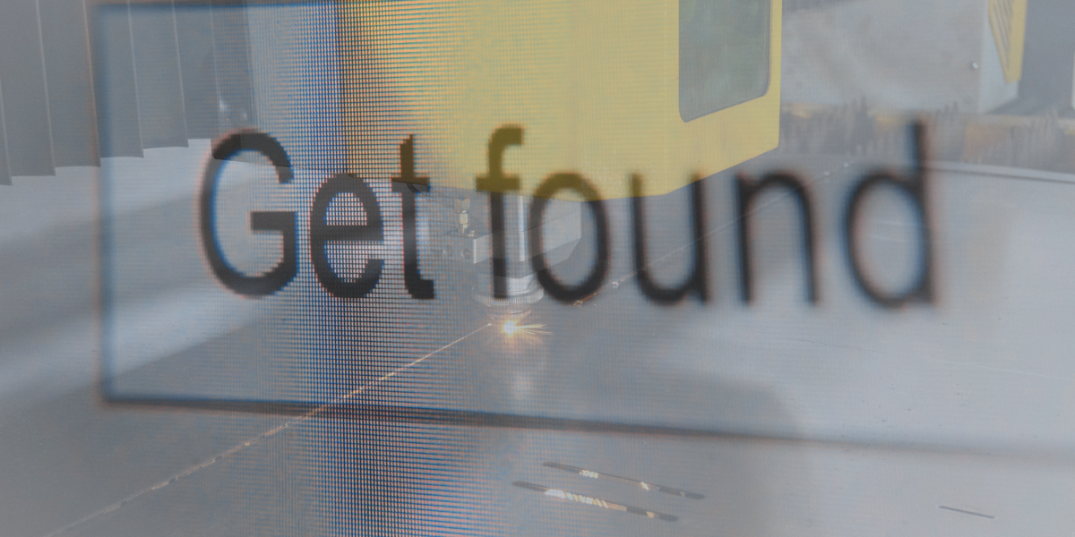 Industrial cutting machine behind the words “Get found,” representing manufacturing visibility in search and AI.
